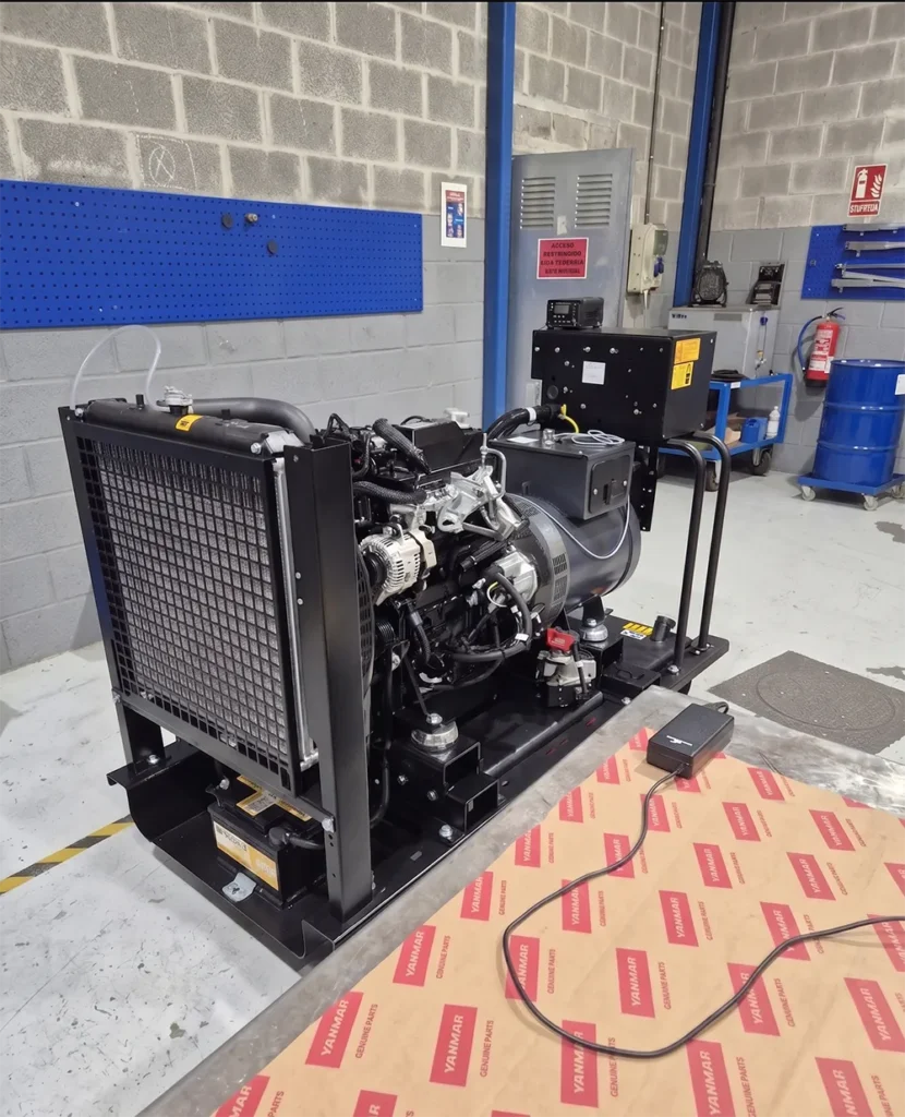An industrial engine on a stand in a workshop. The engine is black with various components exposed.